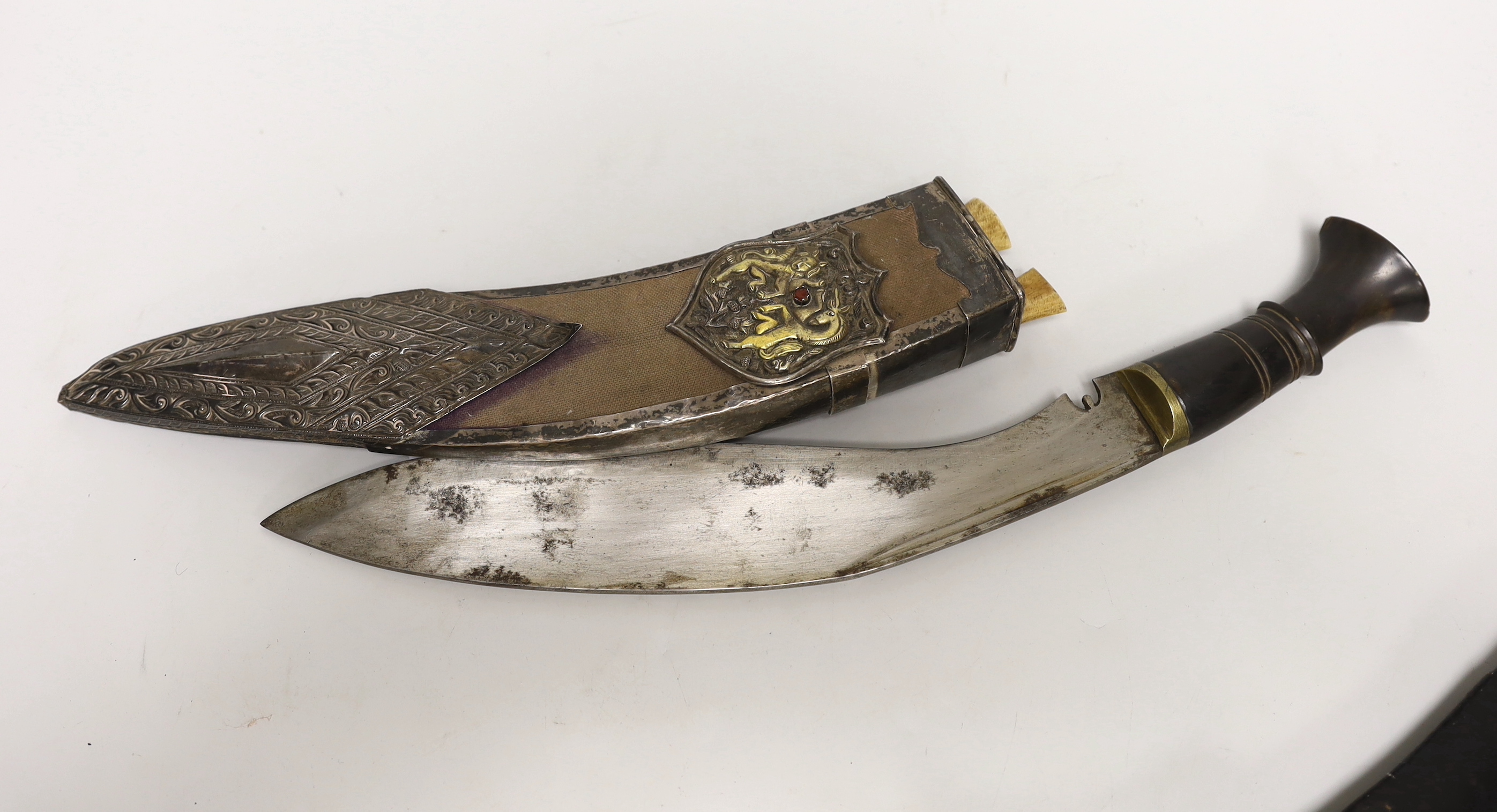 A kukri within white metal mounted sheath, blade 27cm, and three others, one with bone handle